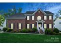 Traditional brick home with manicured lawn and welcoming entrance at dusk at 4015 Amber Leigh Way Dr, Charlotte, NC 28269
