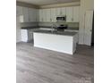 Modern kitchen with white cabinets, gray countertops, and a central island at 405 Webb Rd, Shelby, NC 28152