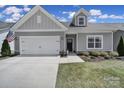 Charming single-story home featuring a two-car garage, American flag, and well-manicured front yard at 5101 Helmsworth Dr, Waxhaw, NC 28173
