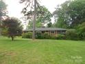Well-maintained single-story brick home with mature trees and a green lawn at 5209 Markay St, Matthews, NC 28105