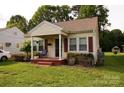 Adorable home featuring a covered porch, red shutters, and landscaped garden at 615 Mauney Ave, Kings Mountain, NC 28086