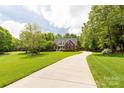 Long driveway leading to a well-manicured lawn surrounded by mature trees, ensuring privacy and a park-like setting at 728 Palmers Pl, Rock Hill, SC 29730