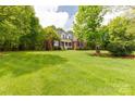 Lush front lawn with mature trees surrounding a well-maintained brick home with a welcoming front porch at 728 Palmers Pl, Rock Hill, SC 29730