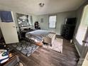 Bedroom with wood floors, stylish rugs, and a decorative wall painting, creating a cozy and inviting atmosphere at 739 Old Charlotte Sw Rd, Concord, NC 28027