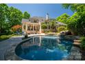 Private backyard oasis featuring a stunning pool, waterfall feature and serene outdoor living space at 8028 Water View Dr, Belmont, NC 28012