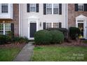 Close-up showcasing the entrance of a townhome with a well-kept lawn, neat bushes, and a paved walkway for a welcoming approach at 8177 Millwright Ln, Charlotte, NC 28277