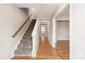 Inviting hallway with hardwood floors leading to a carpeted staircase, creating a seamless transition between spaces at 8177 Millwright Ln, Charlotte, NC 28277