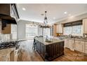 Bright kitchen features an oversized island, stainless steel appliances, dark wood floors, and light countertops at 8239 Victoria Lake Dr, Waxhaw, NC 28173