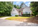 Charming home features a two-car garage, well-maintained lawn, manicured bushes, and a red front door at 9066 Tulagi Ct, Tega Cay, SC 29708