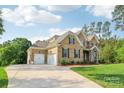 Charming brick home featuring a three-car garage and a well-manicured lawn at 1004 Princesa Dr, Matthews, NC 28104