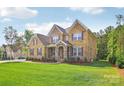 Attractive two-story brick home with manicured lawn and professional landscaping at 1004 Princesa Dr, Matthews, NC 28104