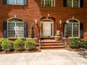 Charming front entry with brick steps, decorative plants, and arched windows at 1209 S South St, Gastonia, NC 28052