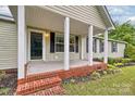 Welcoming front porch with brick accents, pillars, and ample room for seating at 1774 Wintertide Rd, Jefferson, SC 29718