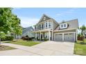 Charming two-story home featuring a three car garage, covered porch and manicured lawn at 1963 Felts Pkwy, Fort Mill, SC 29715