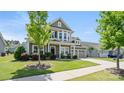 Beautifully landscaped front yard with a two-story home featuring a welcoming porch and an attached two-car garage at 1963 Felts Pkwy, Fort Mill, SC 29715