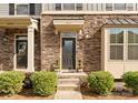 Inviting front door with stone facade, decorative plants, and manicured shrubs enhances curb appeal at 2037 Birchside Dr, Charlotte, NC 28205