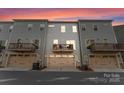 Rear view of townhomes featuring garages, outdoor living space, and neutral siding for a modern look at 2037 Birchside Dr, Charlotte, NC 28205