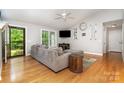 Bright living room featuring hardwood floors, a ceiling fan, a large sofa, and natural light at 204 Millwheel Ln, Mount Gilead, NC 27306