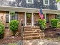 Inviting brick stairs lead to the front door, accented by an American flag and manicured landscaping at 2731 Creekbed Ln, Charlotte, NC 28210