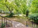 View from the front door looking out to the spacious front yard with mature trees and a long driveway at 2731 Creekbed Ln, Charlotte, NC 28210