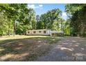 Spacious property showcasing a white single-story home with a carport and a generous front yard at 3317 Treyburn Dr, Midland, NC 28107