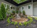 Backyard water feature with stone accents surrounded by lush plantings and verdant landscaping at 3385 Rainbow Dr # 7A, Marvin, NC 28173