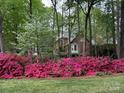 Brick home framed by trees and vibrant pink azaleas at 3804 Bellingham Ln, Charlotte, NC 28215