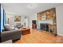 Inviting living room featuring a stone fireplace, hardwood floors and neutral color palette at 401 Clover Ln, Newton, NC 28658