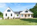 Exterior view of a two-story home with white siding, black trim, and a welcoming front porch with rocking chairs at 4453 Buffalo Shoals Rd, Maiden, NC 28650