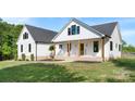 Detailed view of a two-story home's front porch, featuring rocking chairs, white siding, and craftsman-style details at 4453 Buffalo Shoals Rd, Maiden, NC 28650