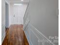 Welcoming entryway featuring hardwood floors, white wainscoting, and a bright front door at 4501 Bainview Dr, Mint Hill, NC 28227