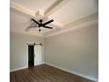 Bedroom with tray ceiling, ceiling fan, and a barn door leading to an adjacent room at 5751 Selkirk Dr, Hickory, NC 28601