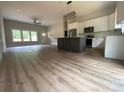 Open-concept living room and kitchen with hardwood floors and modern light fixtures at 5751 Selkirk Dr, Hickory, NC 28601