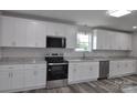 Modern kitchen with stainless steel appliances, white cabinets and beautiful granite countertops at 602 Still St # 1 Blk C, Chester, SC 29706