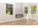 Bright living room featuring wood floors, a modern fireplace, and large windows for natural light at 620 Palmer Sw Ave, Concord, NC 28027
