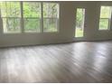 Bright open-concept living area featuring abundant natural light, hardwood style flooring, and neutral paint at 631 S Elm St, Statesville, NC 28677