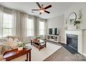 Cozy living room with a fireplace, ceiling fan, and natural light at 6842 Berewick Commons Pkwy, Charlotte, NC 28278