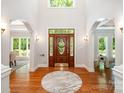 Grand foyer boasts hardwood floors, arched openings, and a custom leaded glass front door at 6868 St Peters Ln, Matthews, NC 28105