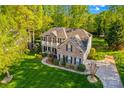 Aerial view of brick home with manicured lawn, lush landscaping, and a spacious driveway at 7896 Harbor Master Ct, Denver, NC 28037