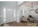Bright foyer with stylish chairs, front door with sidelights, and elegant chandelier at 7905 Sedgebrook E Dr, Stanley, NC 28164