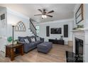 Comfortable living room featuring a ceiling fan, staircase, and entertainment area at 7905 Sedgebrook E Dr, Stanley, NC 28164