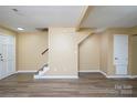 Spacious basement featuring updated flooring and a staircase, ready for customization and finishing at 8835 Hunter Ridge Dr, Charlotte, NC 28226
