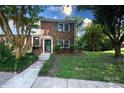 Charming two-story brick townhome with lush landscaping, a well-kept lawn, and a inviting walkway at 8835 Hunter Ridge Dr, Charlotte, NC 28226