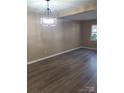 Bright living room with modern lighting fixture and wood-look flooring at 8835 Hunter Ridge Dr, Charlotte, NC 28226