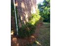 Home exterior featuring maintained garden beds with healthy shrubs and beautiful brick wall at 8835 Hunter Ridge Dr, Charlotte, NC 28226