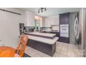 Cozy kitchen featuring white and gray cabinets, updated appliances, and eat in bar seating at 910 E Center Ave, Mooresville, NC 28115