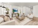 Bright living room featuring hardwood floors, a large TV, and comfortable seating at 9423 Weston Woods Ln, Charlotte, NC 28216