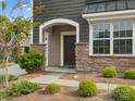 Inviting front porch with stone accents, an arched entryway, and well-maintained landscaping at 9620 Fire Bellied Ct, Lancaster, SC 29720