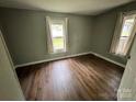 Cozy bedroom featuring wood flooring and two windows providing natural light at 1025 Martin Luther King Jr Dr, Albemarle, NC 28001