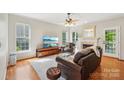 Inviting living room featuring hardwood floors, a cozy fireplace, and ample natural light from large windows at 10316 Willingham Rd, Huntersville, NC 28078
